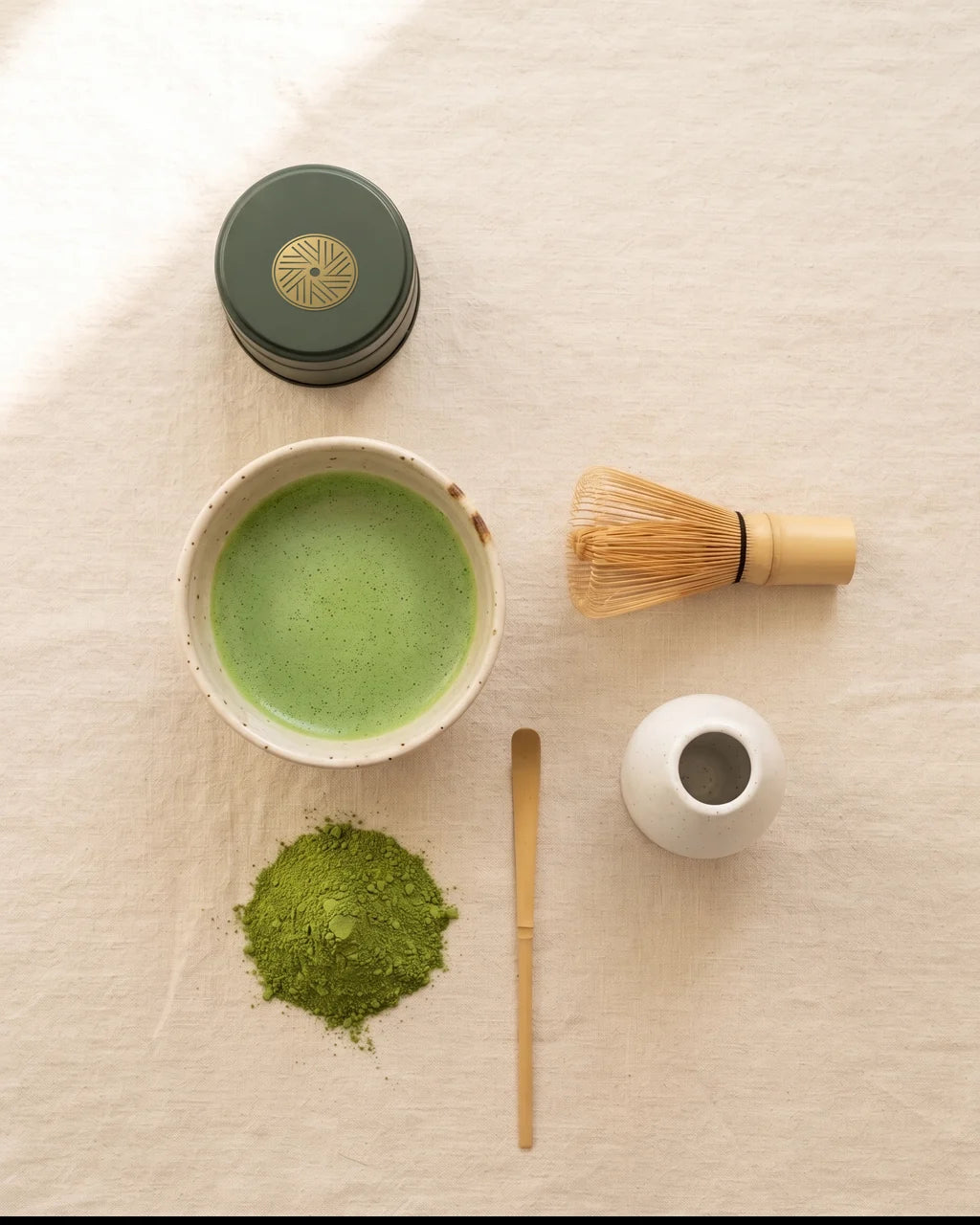 Ritualsættet set fra oven: dåsen med guldseglet, skål med pisket matcha, bambuspisker, piskeholder og bambusske